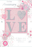 This anniversary card design feels like a whispered promise shared on a quiet walk through Harringay, with a palette of soft pastel pinks, silvery greys, and gentle whites setting an intimate tone. At its centre, the word LOVE stands proudly in raised, glittered lettering, the surfaces dusted with fine, shimmering particles and the edges highlighted in cool silver. The letter O is transformed into a softly rounded heart shape, also textured in silver, giving the focal point a tender, tactile presence. Behind this, a smooth blush-pink background spreads across the card, subtly luminous as though lit from within. Surrounding the word, delicate blooms and curling vines spread outward in an airy composition that recalls the lines of a romantic bouquet planned by a seasoned florist. The flowers, in tones of blush, mauve, and ivory, are drawn with fine outlines and gentle shading, echoing the dreamy look of watercolour. Between them, tiny swirls, scattered petals, and the faint suggestion of butterflies bring lightness and a sense of movement, reminiscent of spring gardens and nearby green spaces. At the top and lower portion of the design, the scripted phrases On Our Anniversary and I love you today and always are written in an understated, elegant font that matches the calm beauty of the artwork. The card's surface seems smooth yet varied, with raised lettering inviting fingertips to explore. Overall, it feels like a keepsake designed to honor shared years and quiet milestones, a paper expression of enduring romance that would pair perfectly with an anniversary bouquet delivered to a Harringay home.